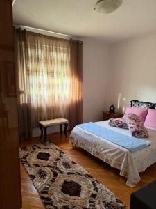 a bedroom with a bed and a rug at Apartman Damir in Čeluga