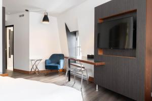 a hotel room with a television on a wall at Hotel Le Saint-Paul in Quebec City