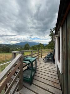 a wooden deck with benches on the side of a building at Britania Hobbit in Predeluţ