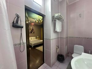 a bathroom with a sink and a toilet and a mirror at Dostyq in Astana