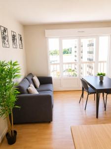 a living room with a couch and a table at L'Élégant - 2 Voyageurs in Reims