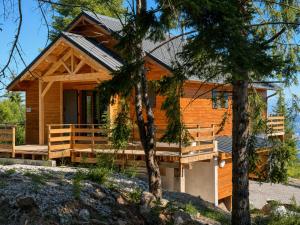 a log cabin with a porch and two trees at Le Chalet in Selonnet