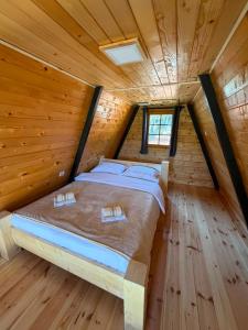 a bed in a log cabin with a window at Vikendice Pod Hum Kučka Korita in Korita