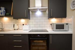 a kitchen with a microwave oven and a stove at Cuil Steading in Cairndow +21 photos