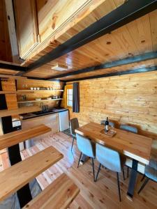 a dining room with wooden walls and a table and chairs at Vikendice Pod Hum Kučka Korita in Korita +26 photos