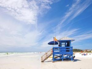a blue life guard stand on a beach with an umbrella at Walk to Siesta Key Beach-Remote Worker Friendly -High Speed WiFi- Bikes Included -Private Fenced In -Close to Restaurants, Coffee Houses & Shops - Paisleys Keep it Simple Casita in Siesta Key