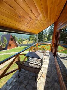 a patio with a table and chairs on a balcony at Vikendice Pod Hum Kučka Korita in Korita