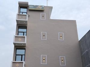 a tall building with windows and a sign on it at Drip Home Stay AKTU in Lucknow