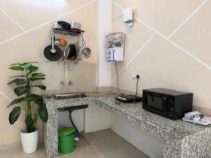 a kitchen with a counter with a microwave and a sink at Drip Home Stay AKTU in Lucknow