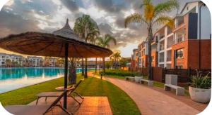 a patio with an umbrella next to a pool at Aurevia Properties in Pretoria