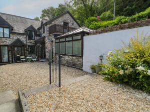 an external view of a house with a gravel driveway at Ivy Cottage in Abergele