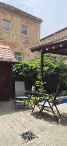 a patio with a table and chairs and a building at Ferienwohnung am Töpferberg in Löbau