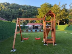 a playground with three swings in a yard at Villa Maria in Ribarica