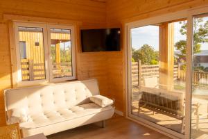 a living room with a white couch and a television at Raíces da Costa Ártabra in Islote Mouron
