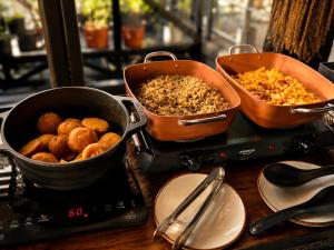 a counter with two pans of food on a table at The Art Hotel El Poblado Medellín By Key 33 in Medellín +81 photos