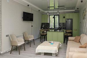 a living room with green cabinets and a kitchen at EVORI Guesthouse in Dilijan
