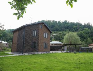 a large brick house in a field of grass at EVORI Guesthouse in Dilijan
