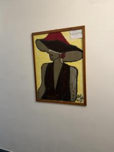 a painting of a woman in a hat on a wall at Rifugio Escursionistico Locanda Borgo Villa in Acceglio