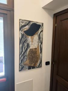 a painting hanging on a wall next to a door at Rifugio Escursionistico Locanda Borgo Villa in Acceglio