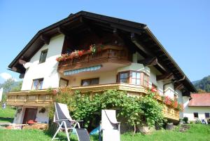 a building with a balcony and flowers on it at Appartement Zweikofelblick in Jenig