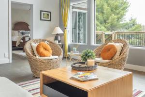 a living room with two wicker chairs and a coffee table at 5-Br Villa on Lake Labelle Chalet Jacob in Labelle