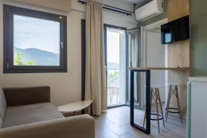 a living room with a couch and a window at Green Hill Thassos in Skala Potamias