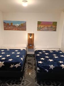 two beds in a room with american stars at Mayka cabañas con JACUZZI in Guatapé