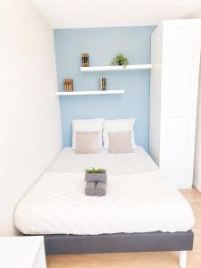 a bedroom with a large bed with white sheets at L'Élégant - 2 Voyageurs in Reims