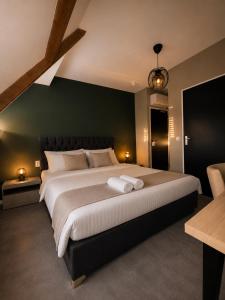 a bedroom with a large bed with a green wall at Boutique Hotel Mare in Middelburg