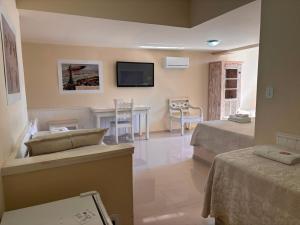 a hotel room with two beds and a television at Pousada 14 Bis in Petrópolis