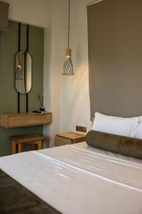 a bedroom with a white bed and a mirror at Green Hill Thassos in Skala Potamias