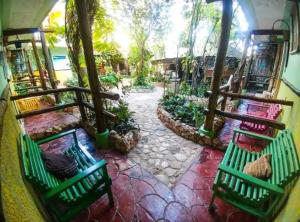 two green benches sitting on a stone patio at Hostal Doña Chava in Pedernales