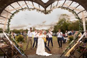a bride and groom walking down the aisle at their wedding at The Apple Farm Glamping in Snitterfield