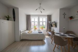 a bedroom with a bed and a table and a window at Apartament in Kętrzyn