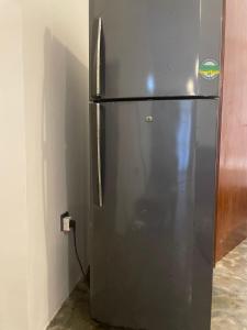 a stainless steel refrigerator in a kitchen next to a wall at Elysian Riverside in Weligama