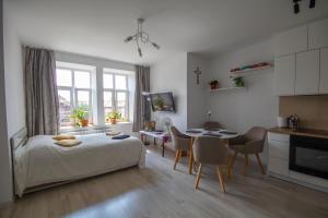 a bedroom with a bed and a table and a kitchen at Apartament in Kętrzyn