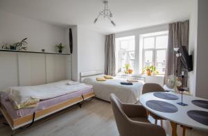 a bedroom with two beds and a table and chairs at Apartament in Kętrzyn