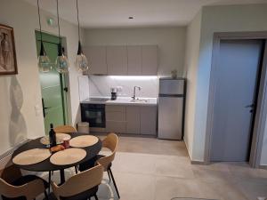 a kitchen with a table and chairs and a refrigerator at Resort Finikas in Alexandroupoli