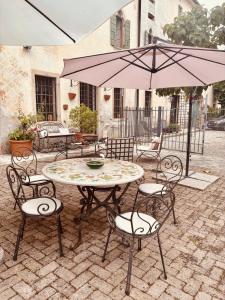 a patio with a table and chairs and an umbrella at BaBi in Cison di Valmarino