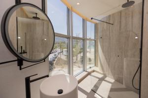 a bathroom with a round mirror and a sink at Quartz Hotel Vlore in Vlorë +105 photos