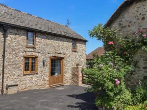an external view of a stone building with a wooden door at Rose Cottage in West Buckland