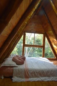 a bed in a wooden room with a window at Alma Silvestre in Puerto Triunfo +13 photos