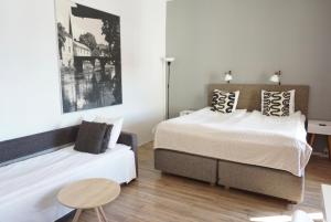 a bedroom with two beds and a table at Arboga Stadshotell in Arboga