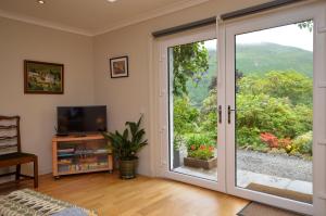 a living room with a sliding glass door at Cuil Steading in Cairndow