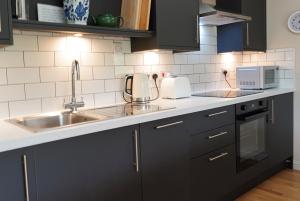 a kitchen with black cabinets and a sink at Cuil Steading in Cairndow