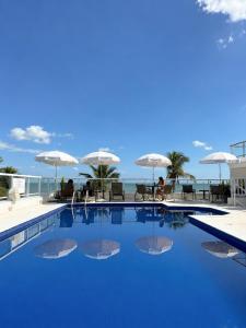 a swimming pool with a view of the ocean at The Falls Hotel - Frente mar in Guarujá