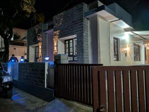 a house with a fence in front of it at night at Cherry guest House Shringeri ,koppa rural in Chikmagalur +6 photos