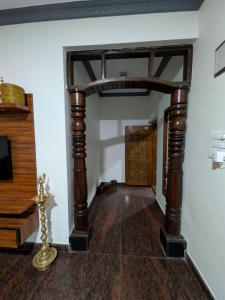 a hallway with a wooden archway in a room at Cherry guest House Shringeri ,koppa rural in Chikmagalur