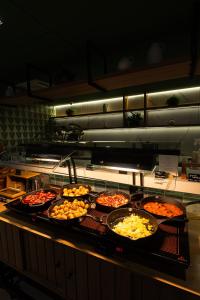 a buffet line with many different types of pizzas at Grand Mercure SP Pinheiros in São Paulo