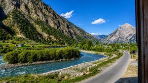 a road next to a river and mountains at Hotel GRITTI CASTLE in Wāmpor